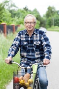 Smiling senior man riding a bicycle