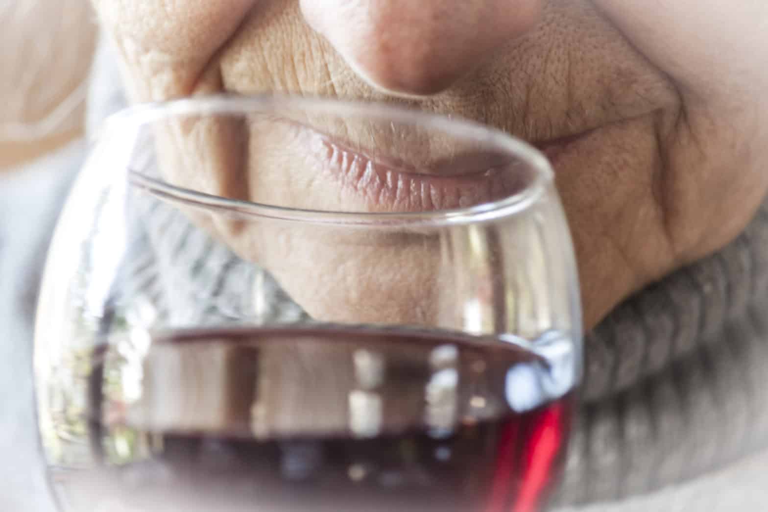 Woman smelling and drinking red wine