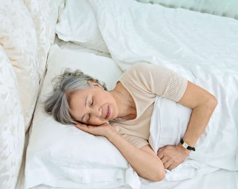 Senior woman lying in bed sleeping.