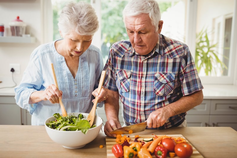 Senior couple preparing salad