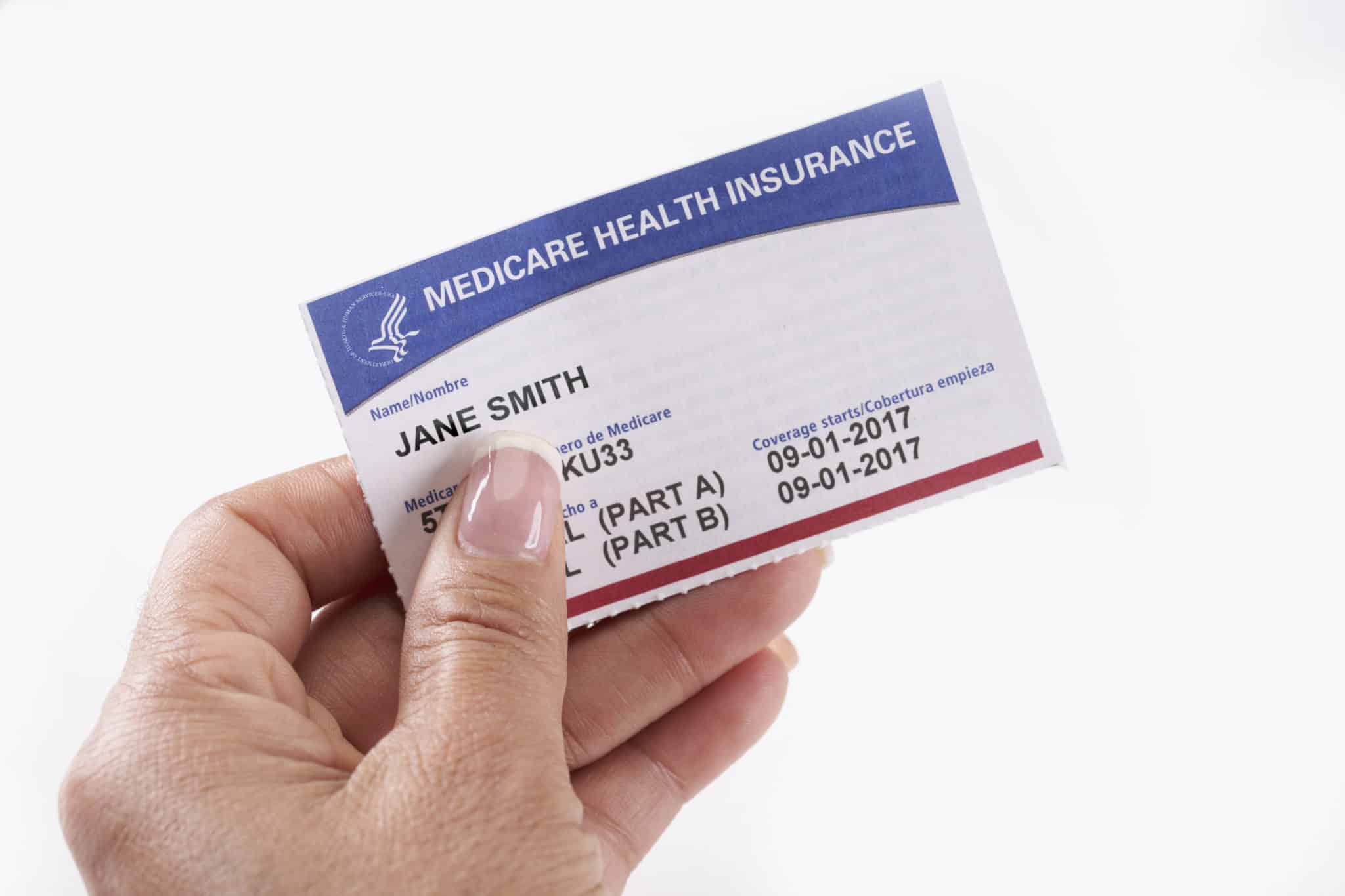 Medicare Health Insurance Card with white background in hand