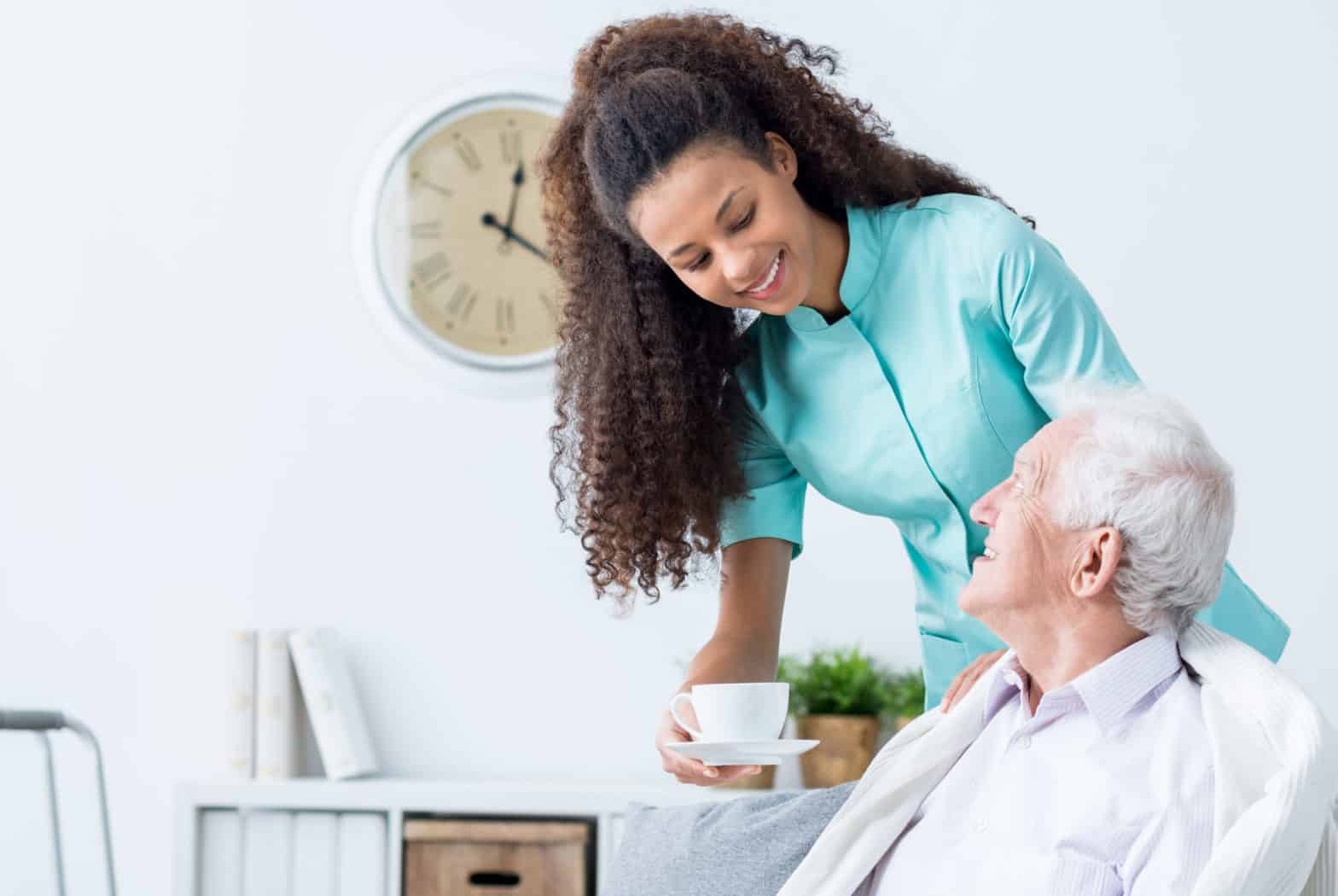 Female caregiver serving afternoon tea to patient