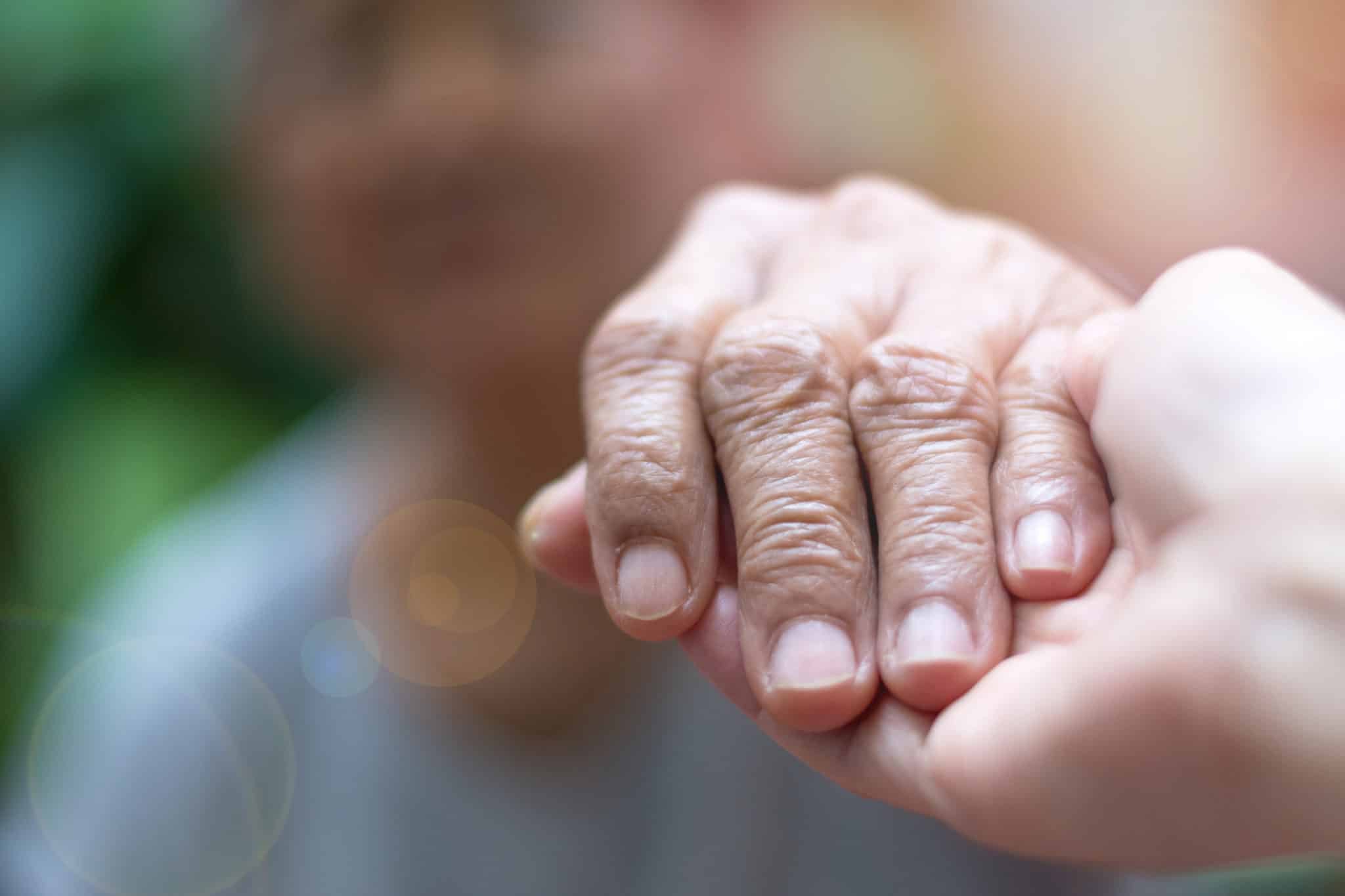 Caregiver, carer hand holding elder hand woman in hospice care. Philanthropy kindness to disabled concept.Public Service Recognition Week