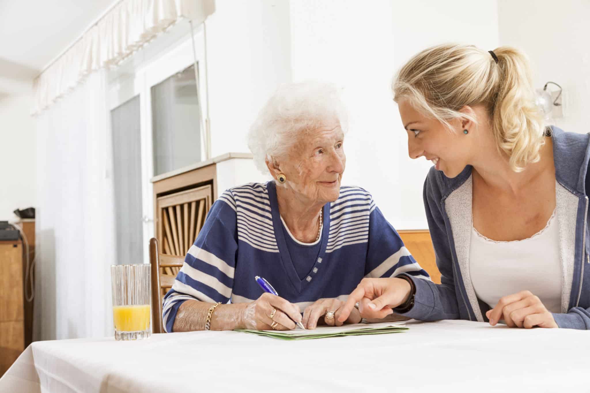 senior woman caregiver paperwork signing last will