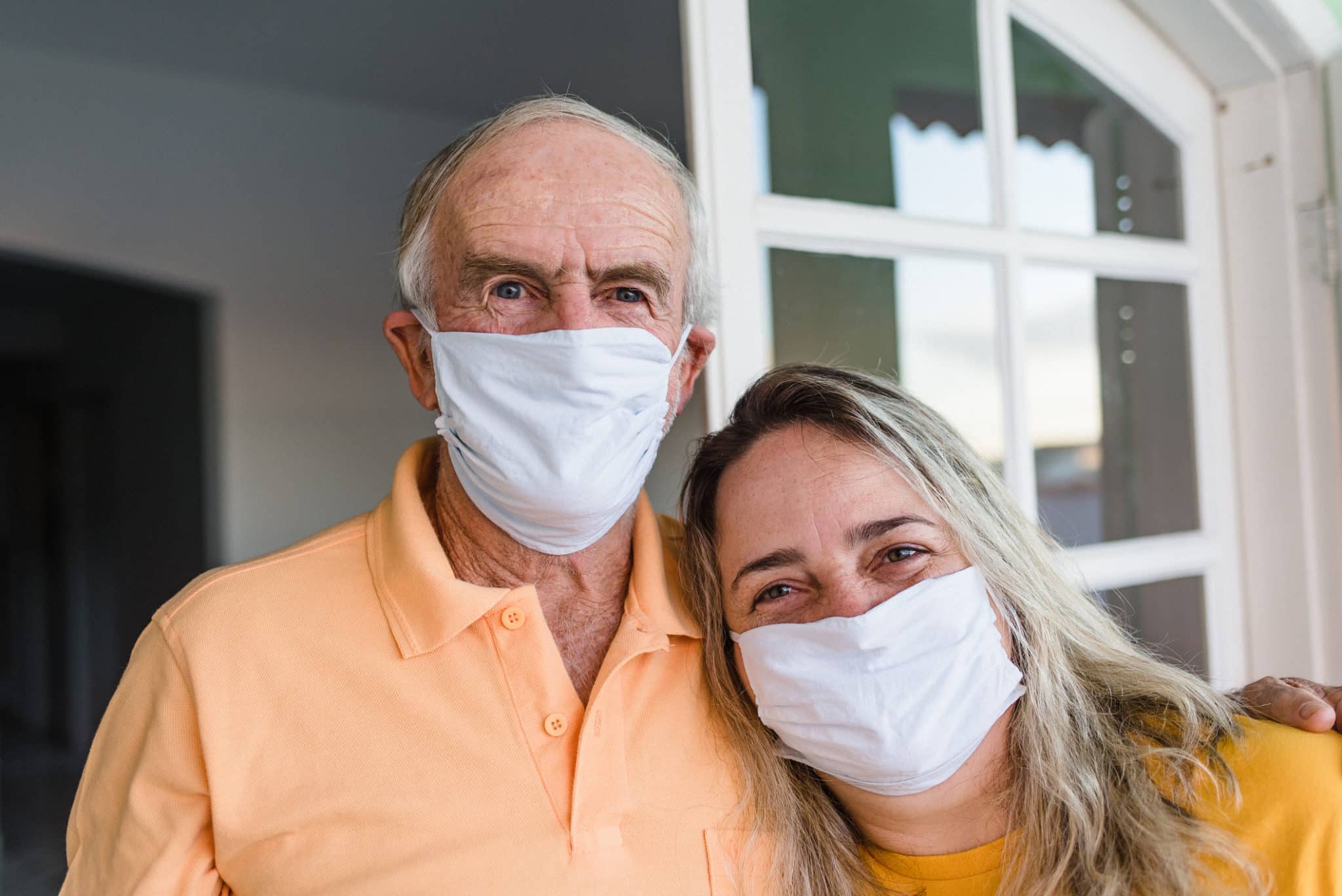 Dad and daughter holding each other using face mask