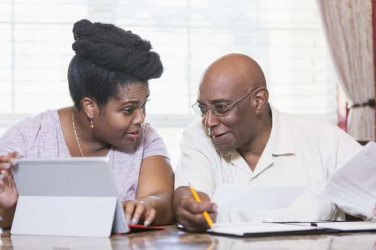 Senior man and adult daughter working on home finances