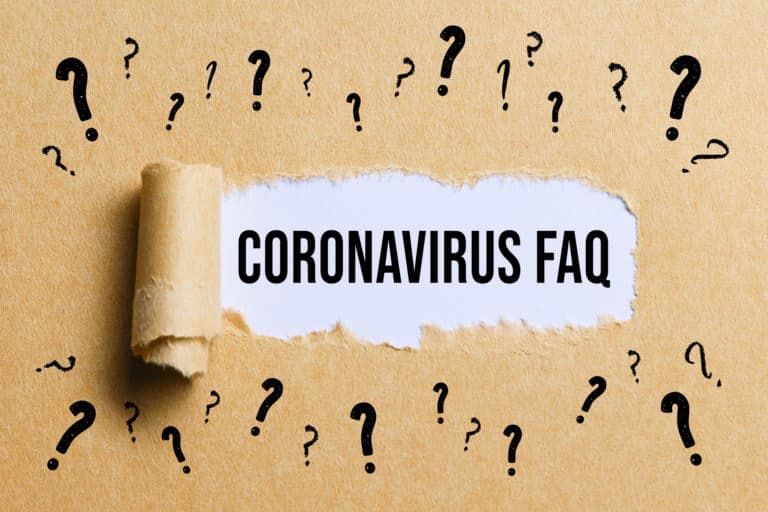 torn paper revealing the text CORONAVIRUS-FAQ