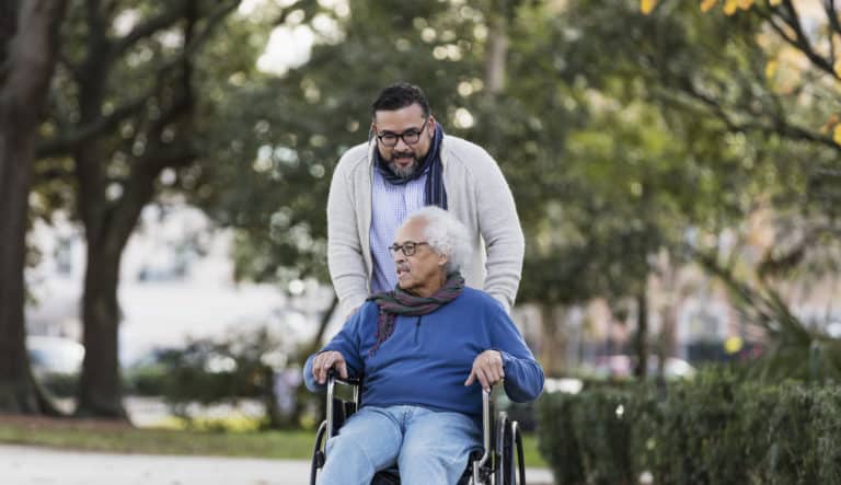 Senior Hispanic man in wheelchair, with adult son