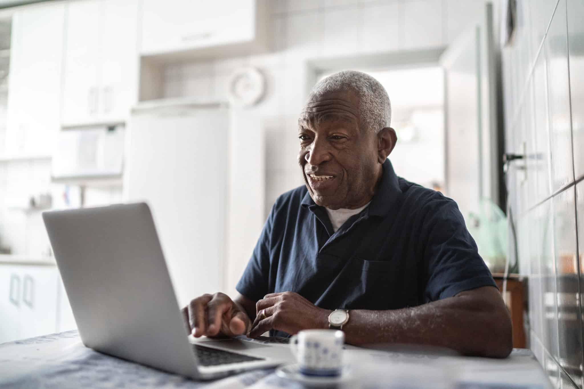 Senior man working at laptop at home