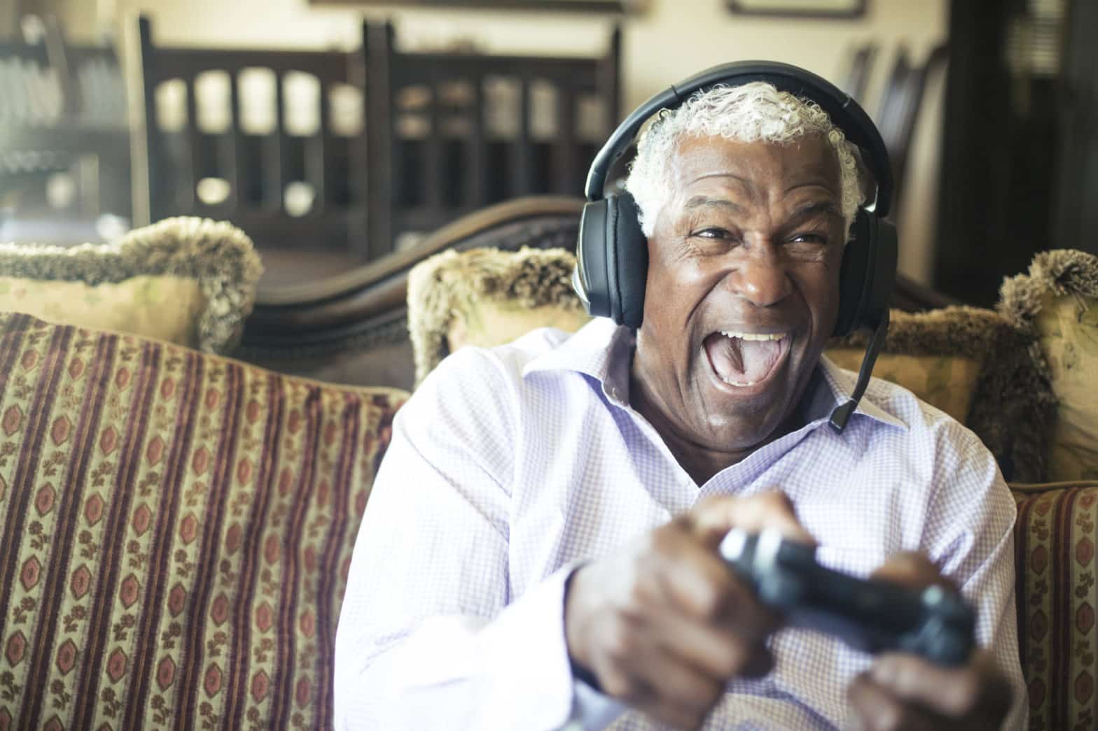 Senior Black Man Playing Video Games with Headphones