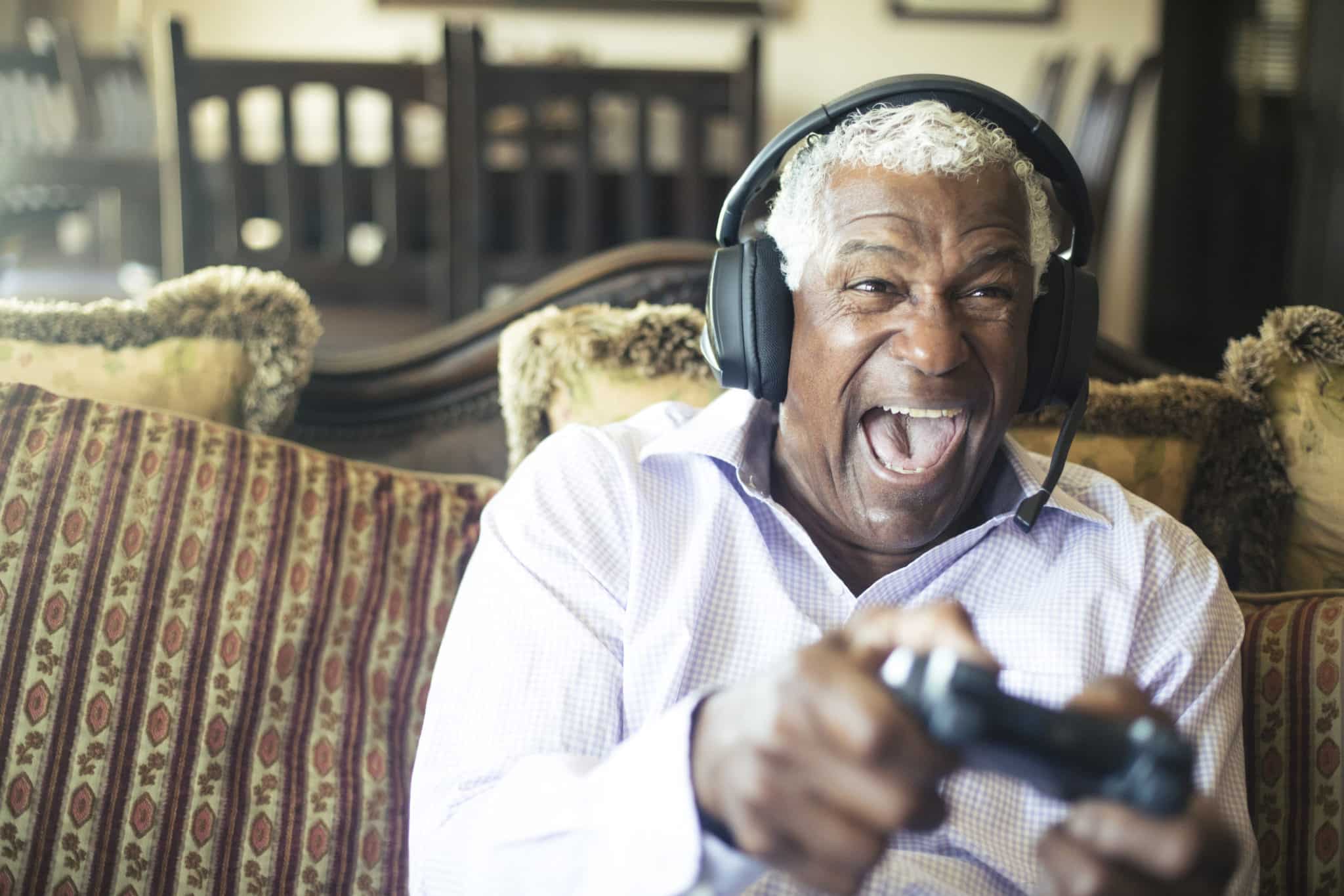 Senior Black Man Playing Video Games with Headphones