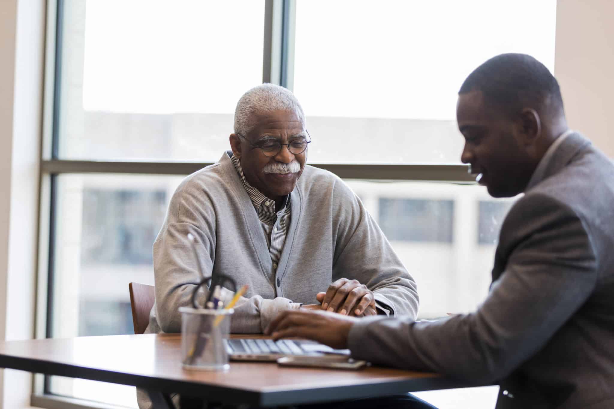 Mid adult loan officer helps senior man find best investment