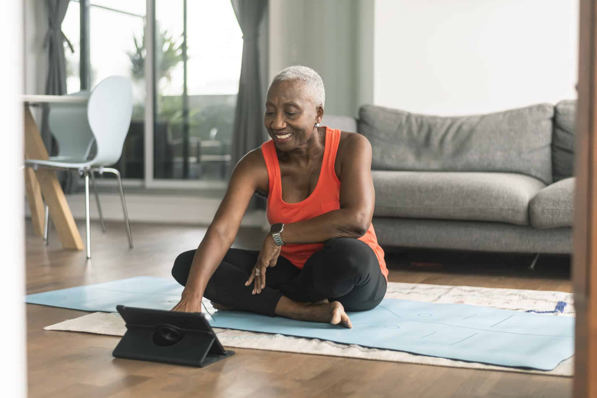 A black senior woman takes an online yoga class