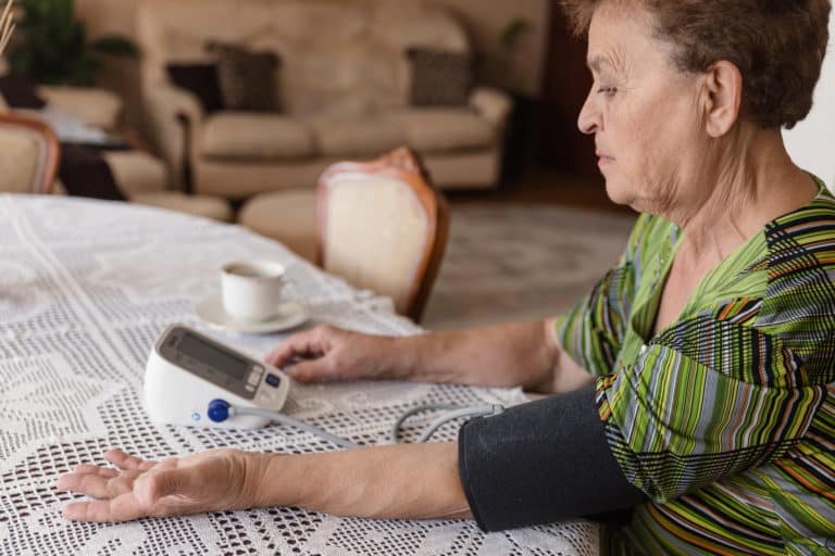 Senior adult woman measuring blood pressure at home