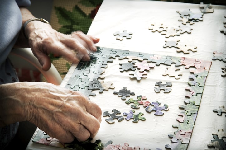 Old woman doing a puzzle