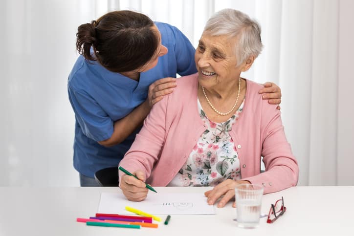 Nursing home therapy- senior woman drawing on white paper