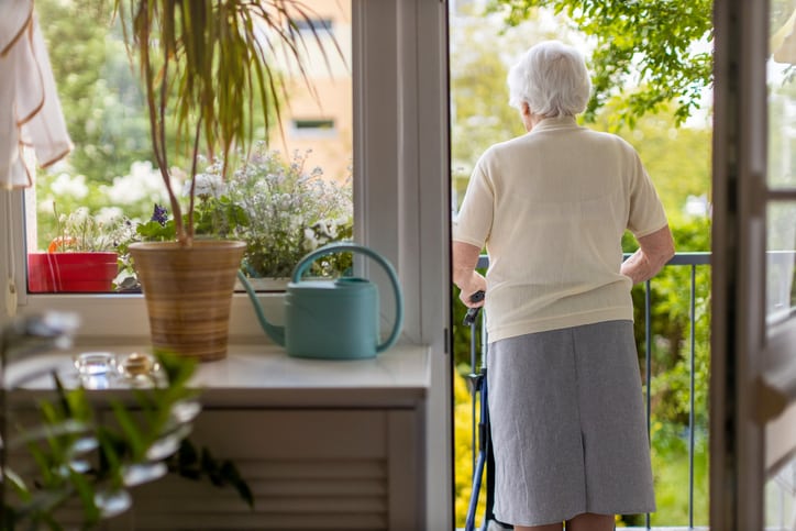 Rear view of a senior woman with walking frame at home