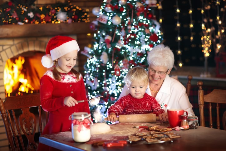 Grandmother and kids bake Christmas cookies.