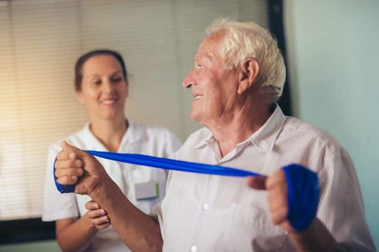 Senior man doing exercises using a strap