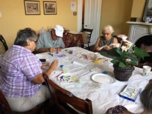 Four seniors immerse themselves in a group watercolor class.