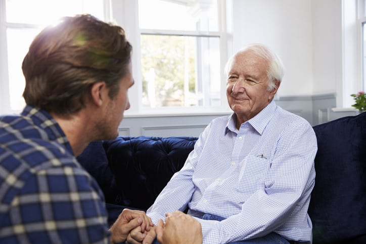 Adult Son Talking To Depressed Father At Home