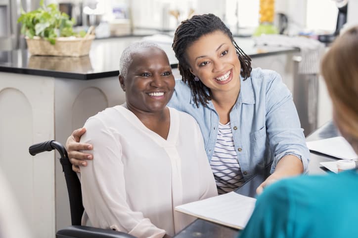 Elderly patient and her daughter talk with home healthcare nurse