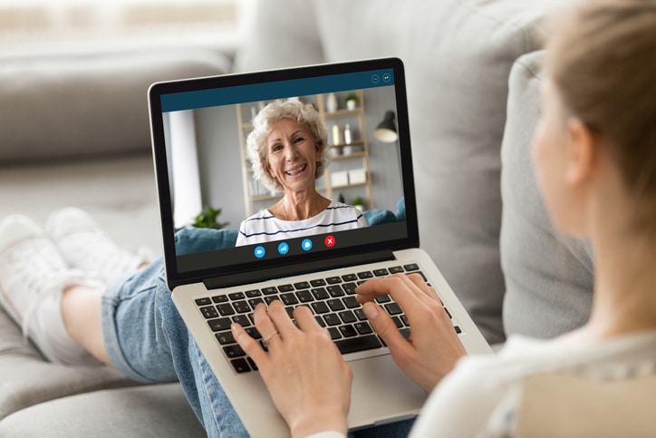 Millennial girl talk on video call with mature mother
