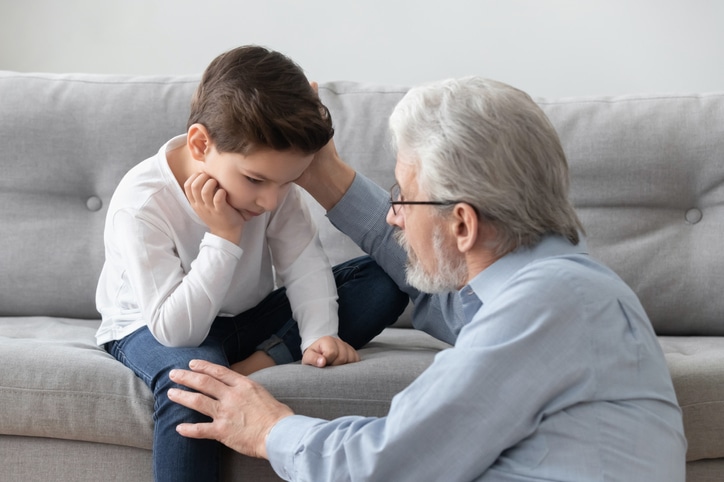 Caring worried senior grandpa comforting sad grandson give psychological help