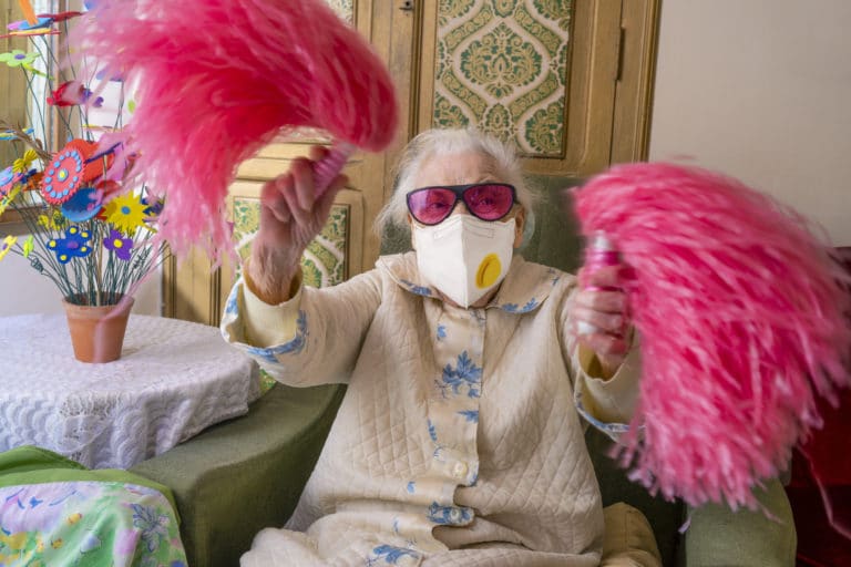 Coronavirus COVID-19 pandemic confinement with mask an humor Cheerleader pom-pom elderly woman happy